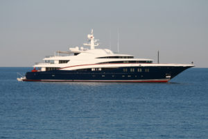 White Super yacht with blue hull and red stripe